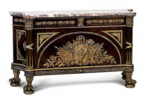 guillaume-benneman commode, A Louis XVI style ormolu-mounted commode a vantaux after the model by Guillaume Benneman, Late 19th century, circa 1890 executed later by Francois Linke Of trapezoid form, the shaped marble top above an oak-leaf frieze leaves set with a pair of drawers, above a pair of panelled doors mounted with ormolu trophies of War and acanthus rosettes, with panelled concave sides and ribbon-tied arrow-form front angle and fluted corners, on acanthus-sheathed hairy paw feet